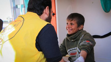 Halep, Suriye 19 Mart 2020 Doktor, muayene sırasında hasta bir çocukla oynuyor