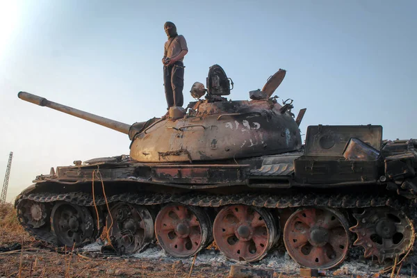 Halep, Suriye 17 Mart 2017: Yok edilmiş bir tankın üzerinde duran savaşçılar. 