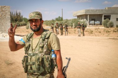 Halep, Suriye 12 Eylül 2017: Silahlı Suriye muhalefetinin savaşçıları IŞİD 'e karşı kazandığı zaferden sonra zafer rozetlerini elleriyle kaldırdılar