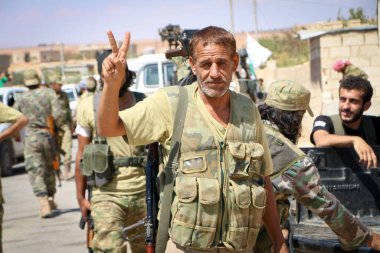 Halep, Suriye 12 Eylül 2017: Silahlı Suriye muhalefetinin savaşçıları IŞİD 'e karşı kazandığı zaferden sonra zafer rozetlerini elleriyle kaldırdılar