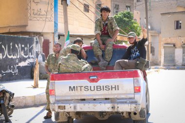 Halep, Suriye 16 Ekim 2016: Suriyeli muhalefet savaşçıları IŞİD 'e karşı kazanılan zaferden sonra askeri araçlara karşı ellerini kaldırdılar