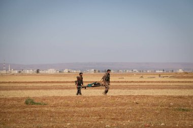 Halep, Suriye, 17 Ekim 2016: Suriye silahlı muhalifleri, IŞİD 'in IŞİD' e yerleştirdiği köyde mayın tarlasına maruz kaldıktan sonra el arabasıyla yaralı bir askeri taşıdılar 