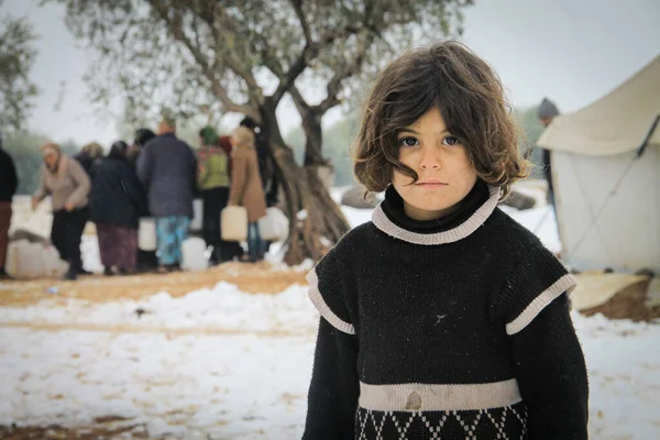 Halep, Suriye, 15 Şubat 2017. Mülteci kız kameraya bakıyor. Kar yağışı nedeniyle soğuk algınlığı belirtileri gösteriyor.