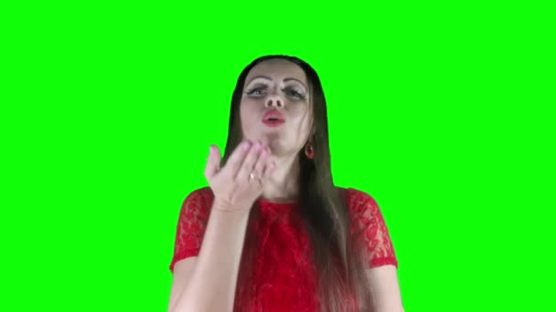 笑顔と空気キス 緑の背景に赤い口紅と赤いドレスで若い美しい女性は クロマキー 隔離されたビデオカラー — ストック動画