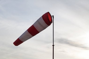 Direkte çizgili kırmızı ve beyaz rüzgarlık rüzgar yönünü gösterir ve çekimde yükselen çapraz, yakın çekim