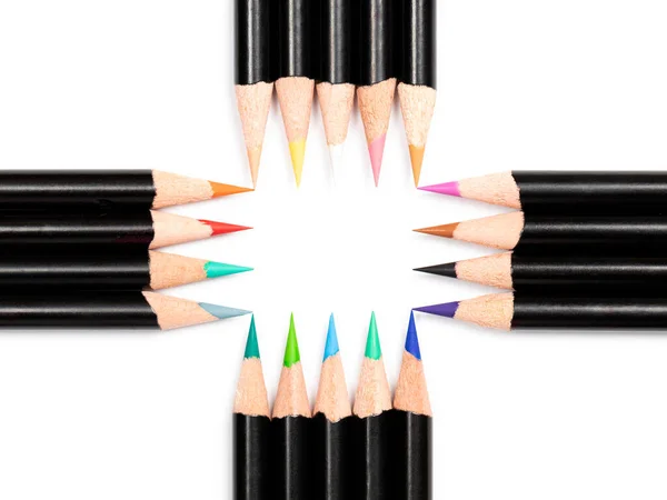 Multicolor pencils make free space frame with dimensions five by four pencils in the center on white background, and there are four free spaces in the corners, close up