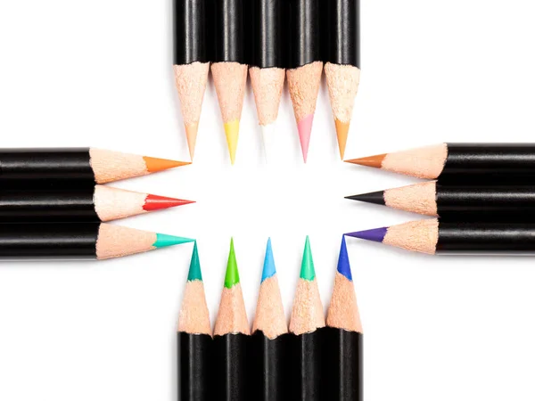 Multicolor pencils make free space frame with dimensions five by three pencils in the center on white background, and there are four free spaces in the corners, close up