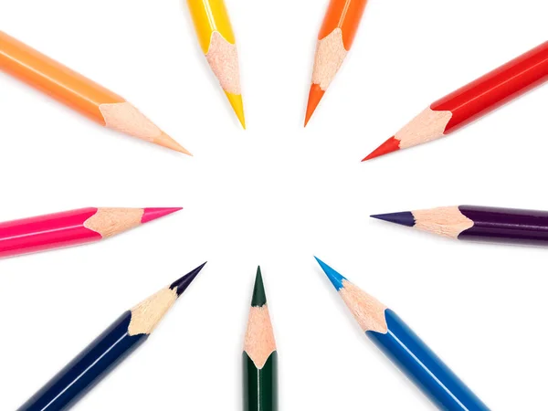 Nine multicolor pencils make oval free space in the center on white background, close up