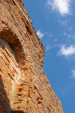Eski Katolik kilisesinin yıkılmış duvarı. Eski bir kilisenin kalıntıları. Tuğla duvar mavi gökyüzü arkaplanı