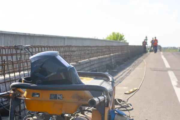 Bridge repair. Welding machine. Welders work on the bridge. Armature frame