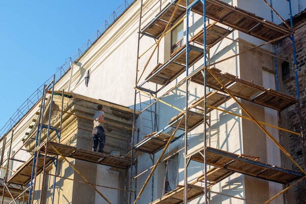 Рабочий на строительных лесах при реставрации
