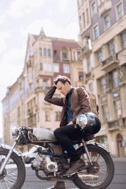 Şehirde motosikletli genç bir adam.