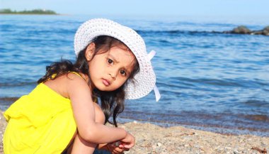 Çocuk sahilde oynuyor. Çocuk dışarıda eğleniyor. Yaz tatili ve sağlıklı bir yaşam tarzı.