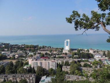 Gerçekten güzel bir deniz manzarası. Önünde şehir, solunda ağaç var..