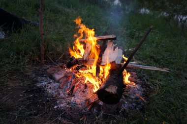 Yeşil çimlerin üzerinde parlak şömine. 