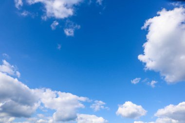 Pofuduk beyaz kümülüs bulutları açık ve güneşli bir günde masmavi bir gökyüzünde.