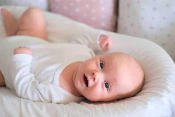 Хорошенький новорожденный ребенок лежит на кровати портрет милого маленького ребенка лежит — стоковое фото