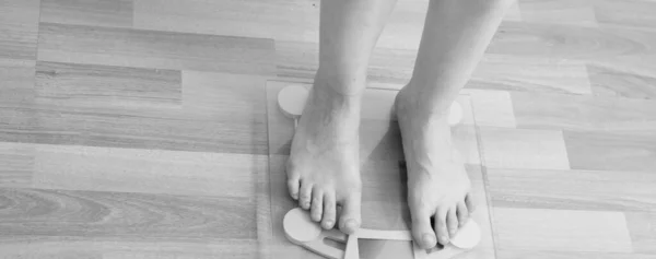 Női lábak összezárva. A testsúly mérésére szolgáló mérlegek. Túlsúlyos fogalom. — Stock Fotó