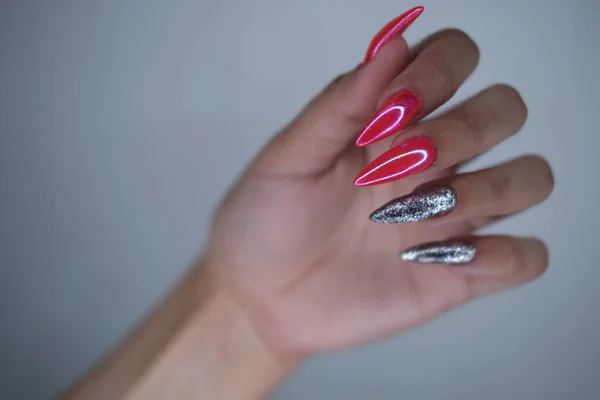 Vrouwelijke handen met verlengde gekleurde nagels close-up. — Stockfoto