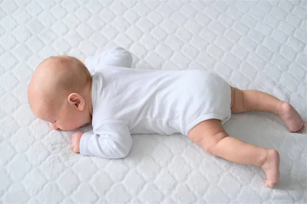 Un bebé recién nacido yace sobre una manta blanca. Retrato de primer plano de un niño — Foto de Stock