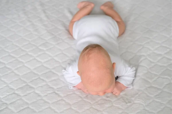 Un bebé recién nacido yace sobre una manta blanca. Retrato de primer plano de un niño — Foto de Stock