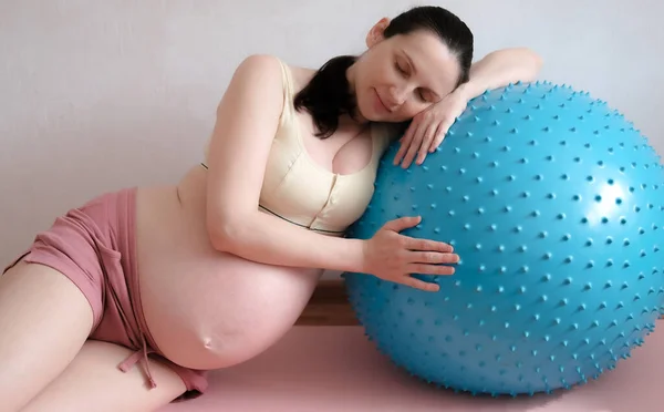 Une femme enceinte fait du sport avec une balle de yoga et de fitness. Concept food, mode de vie sain. — Photo