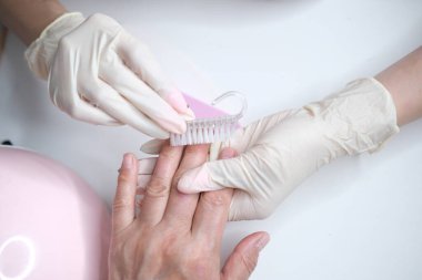 Profesyonel manikür, güzellik salonunda manikür. Eldivenler konusunda ustanın elleri. Tırnaklar parlatılıyor