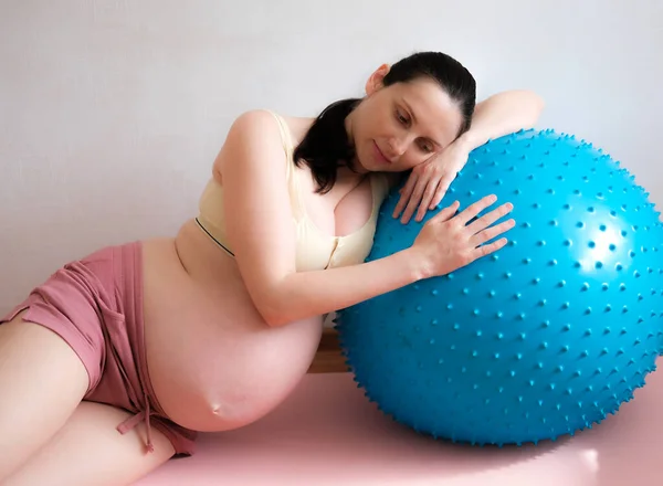 Uma mulher grávida entra para esportes com uma bola de fitness e ioga. Conceito de comida, estilo de vida saudável. — Fotografia de Stock