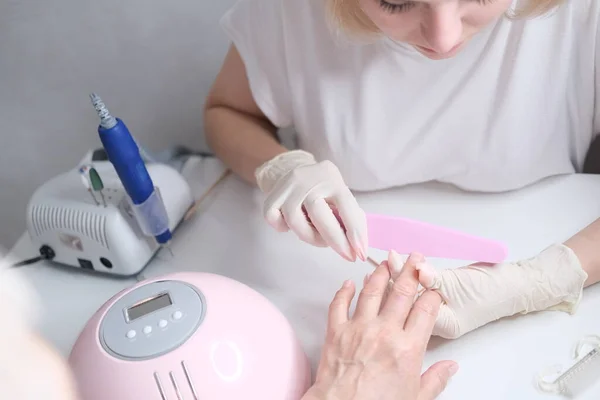 Nail care. Manicure in the salon. The master manicures the girl. Manicure process. — Stock Photo, Image