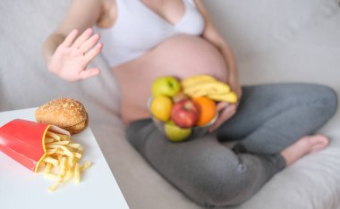Konsept hamilelik, sağlıklı bir yaşam tarzı, kilolu olmak ve diyabet. Hamile bir kadın abur cubur yemeyi reddediyor..