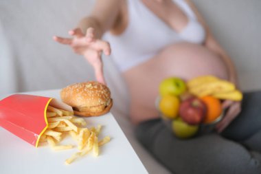 Konsept hamilelik, sağlıklı bir yaşam tarzı, kilolu olmak ve diyabet. Hamile bir kadın abur cubur yemeyi reddediyor..