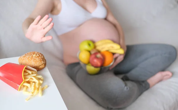 Konsept hamilelik, sağlıklı bir yaşam tarzı, kilolu olmak ve diyabet. Hamile bir kadın abur cubur yemeyi reddediyor..