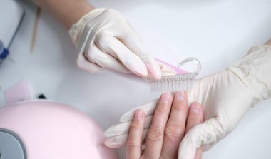 Profesyonel manikür, güzellik salonunda manikür. Eldivenler konusunda ustanın elleri. Tırnaklar parlatılıyor