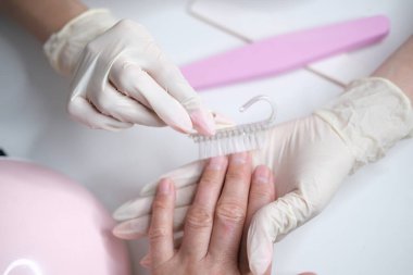 Profesyonel manikür, güzellik salonunda manikür. Eldivenler konusunda ustanın elleri. Tırnaklar parlatılıyor