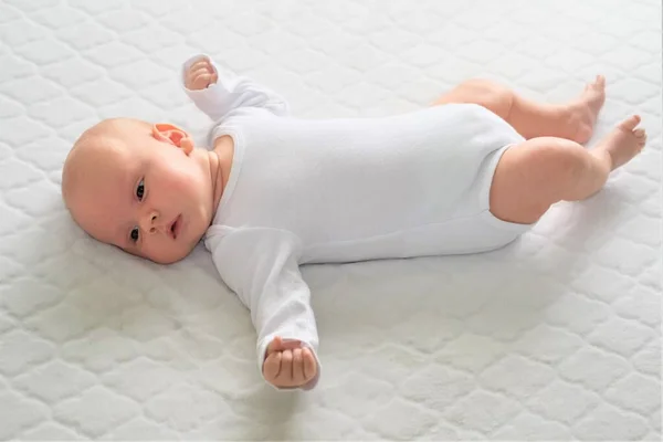 Een pasgeboren baby ligt op een witte deken. Close-up portret van een kind. — Stockfoto