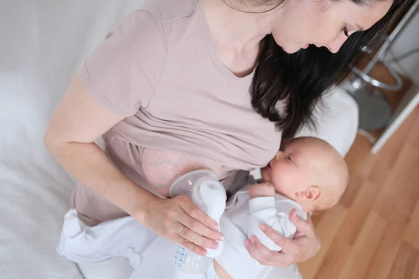 若い女性は彼女の腕や授乳中の新生児を保持します. — ストック写真