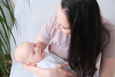 Genç bir kadın yeni doğmuş bir bebeği kollarında tutuyor ve emziriyor. Emzirme konsepti..