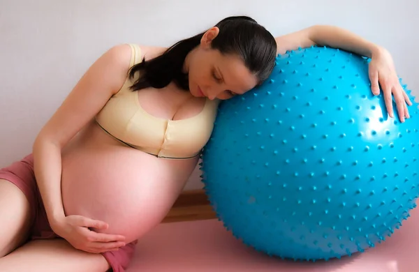 Una mujer embarazada va a practicar deportes con una pelota de fitness y yoga. Comida conceptual, estilo de vida saludable. — Foto de Stock