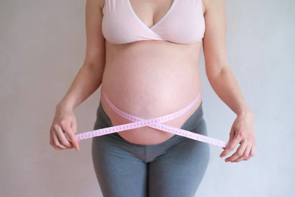 La mujer embarazada mide su vientre. Concepto - nutrición y estilo de vida saludable —  Fotos de Stock