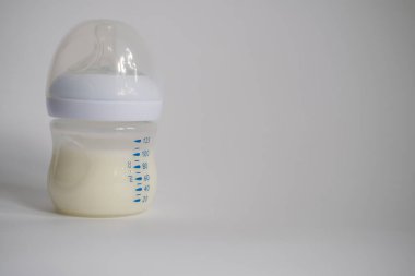 Elektrikli göğüs pompası mutfaktaki masanın üzerinde. İfade edilmiş anne sütü. Genç bir anneye meme bakımı.