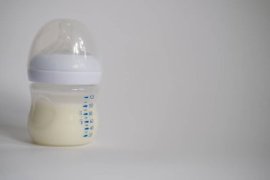 Elektrikli göğüs pompası mutfaktaki masanın üzerinde. İfade edilmiş anne sütü. Genç bir anneye meme bakımı.