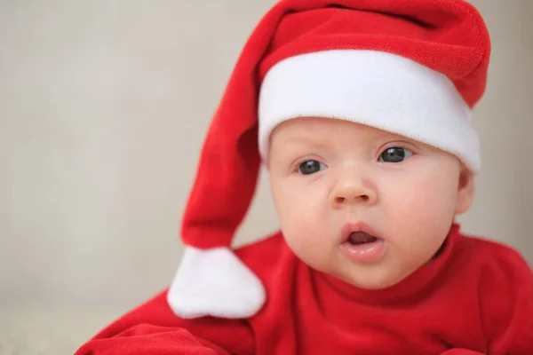 Beyaz arka planda Noel Baba kostümlü bebek. Noel Baba kostümlü sürünen bebek.