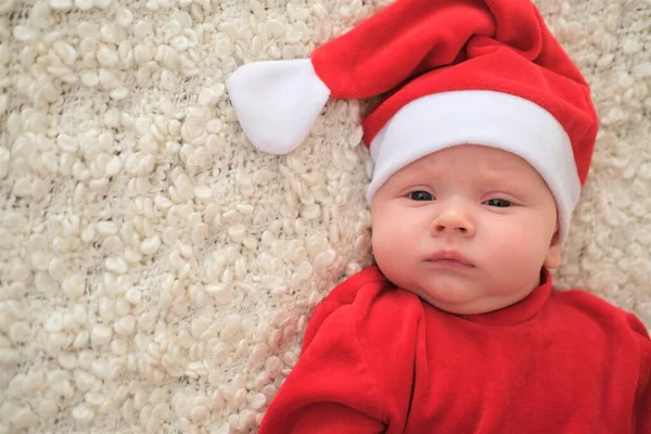 Babbo Natale bambino sdraiato sulla coperta bianca Natale bambino a Babbo Natale cappello — Foto Stock