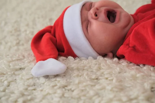 Ο 'γιος Βασίλης ξαπλωμένος πάνω σε λευκή κουβέρτα. Το όμορφο μωράκι γιορτάζει τα Χριστούγεννα. — Φωτογραφία Αρχείου
