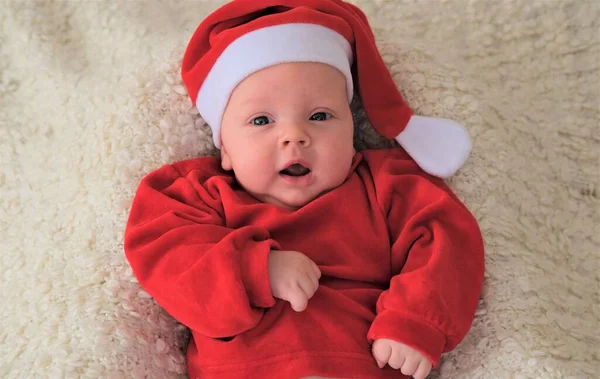 Baby im Weihnachtsmannkostüm auf weißem Hintergrund. Weihnachtskind mit Weihnachtsmütze — Stockfoto