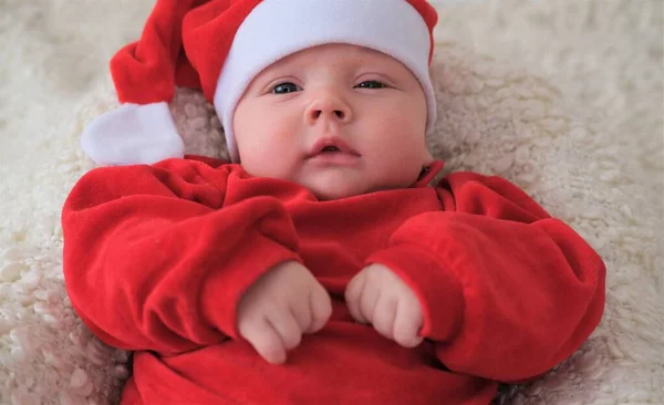 Baby im Weihnachtsmannkostüm auf weißem Hintergrund. Weihnachtskind mit Weihnachtsmütze — Stockfoto