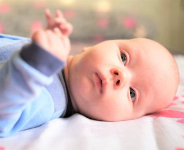  Yeni doğmuş bebek - erkek ya da kız, kırmızı ve parlak pembe kalpleri olan beyaz bir arka planda yatıyor.