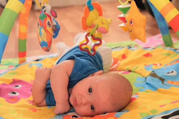 新生男婴或女婴在玩耍。一个可爱的3个月大的婴儿躺在明亮的毛毯上的画像. — 图库照片