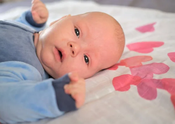 Porträtt av en söt 3 månader gammal baby, isolerad på vit bakgrund med röda och ljusa rosa hjärtan. — Stockfoto