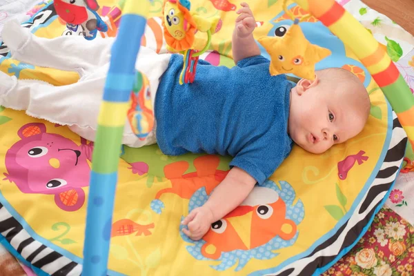 Νεογέννητο μωρό παίζει Πορτρέτο ενός χαριτωμένου μωρού 3 μηνών που βρίσκεται σε μια φωτεινή κουβέρτα. — Φωτογραφία Αρχείου